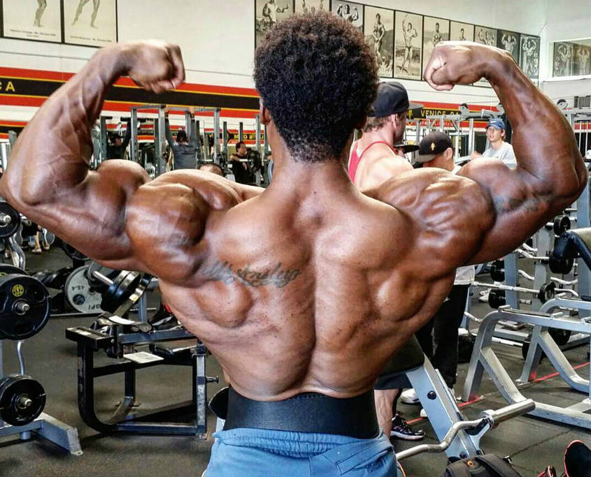 Breon Ansley showing his well-built back and shoulder muscles in the gym 