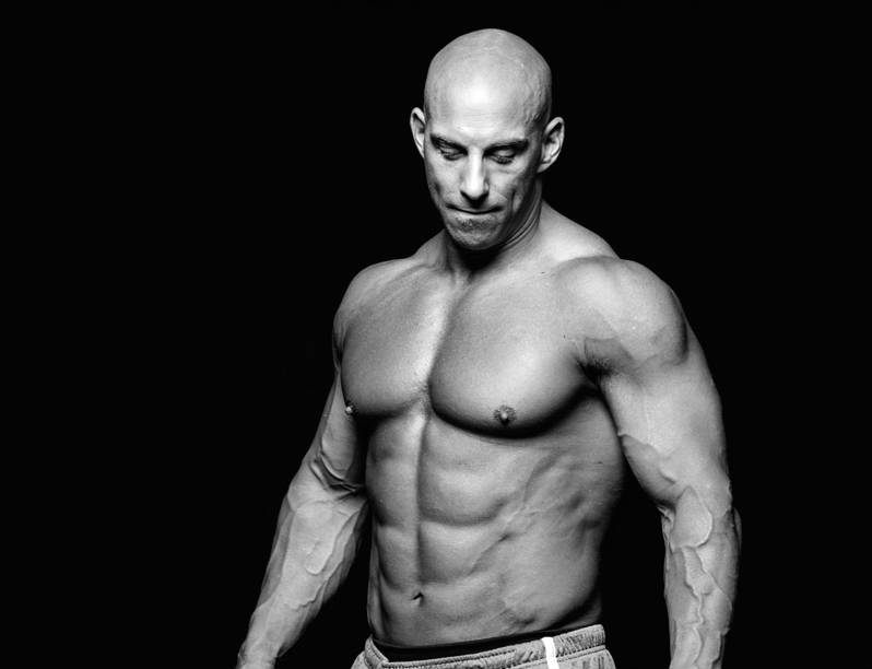 Christian Thibaudeau showing his large, toned abs and pectorals 