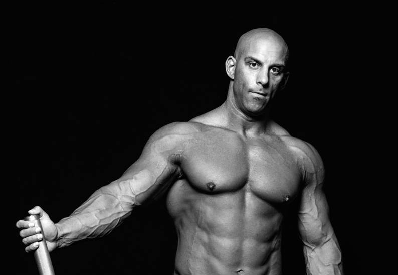 Christian Thibaudeau showing his large abs, chest and vascular arms