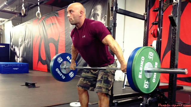 Christian Thibaudeau compelting a snatch lift, showing his large arms and chest 