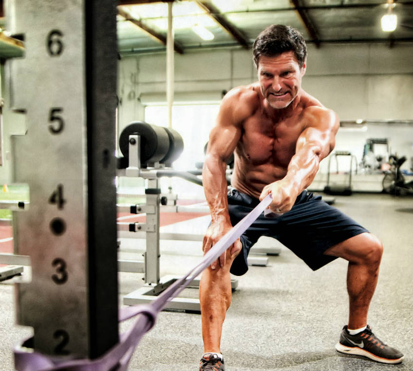 Clark Bartram using a resistance band, working his large arms and delts