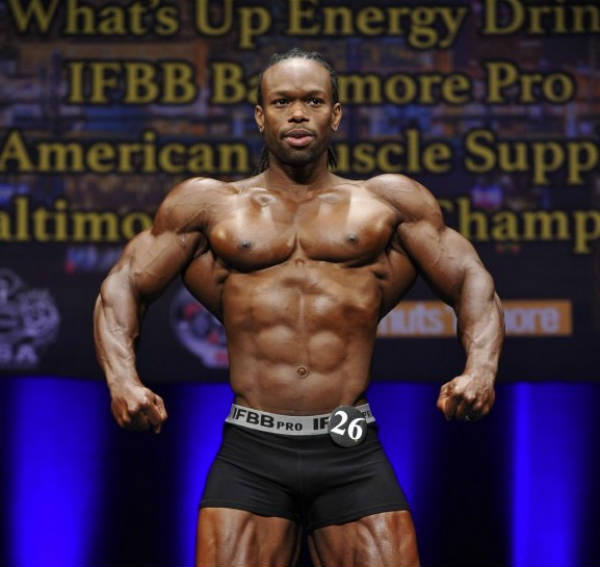 Daron Lytle posing at a competition, showing his ripepd abs, large chest and huge delts