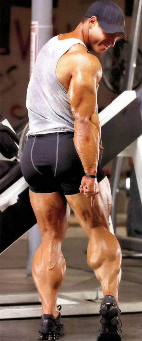 Erik Fankhouser pointing to his large calf following a leg workout