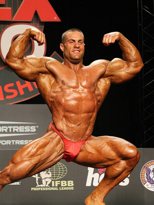 Evan Centopani posing a the flex competition, showing his large biceps, abs and quads