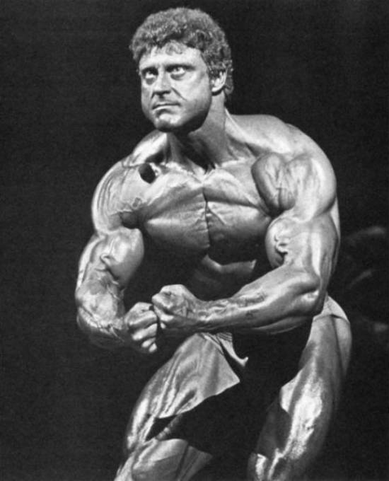 Frank Richards tensing his biceps hard at a competition, showing off his toned and cut body