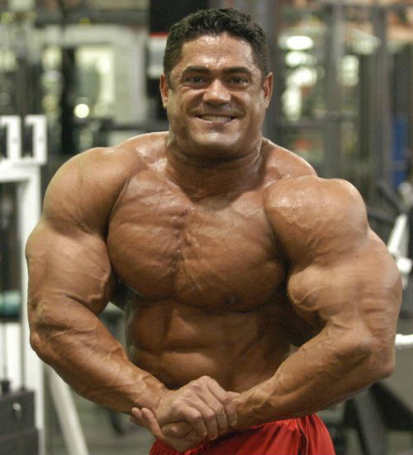 Gustavo Badell tensing his large bicep and showing his vascular chest and arms 