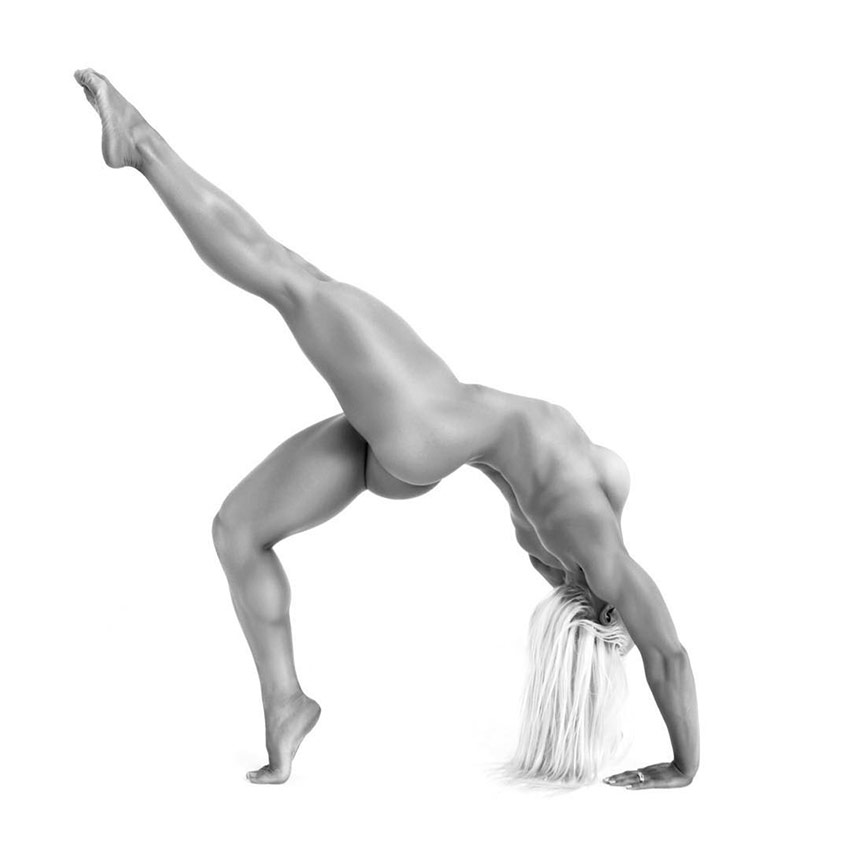 Jade Mead posing naked while performing yoga, displaying the muscular definition on her back, legs, and arms.