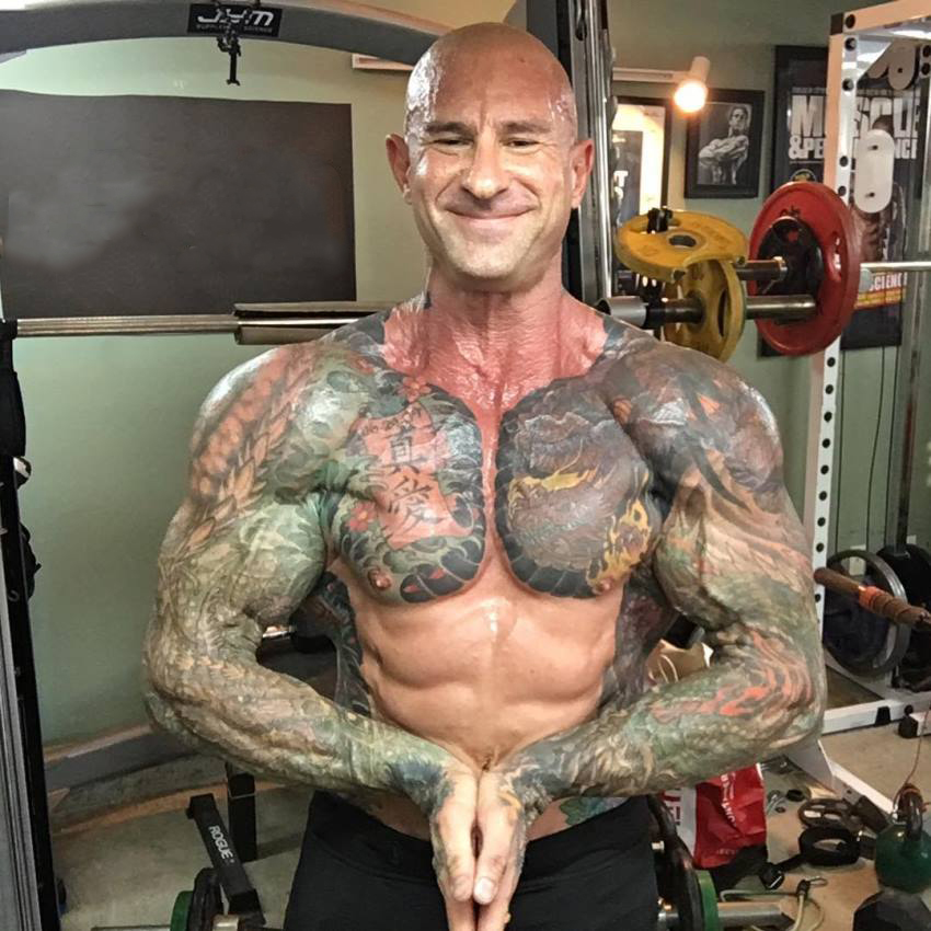 Jim Stoppani in a most muscular pose as he smiles at the camera