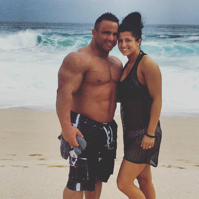 Jose Raymond standing on the beach with his wife, showing off his upper body in the off-season 