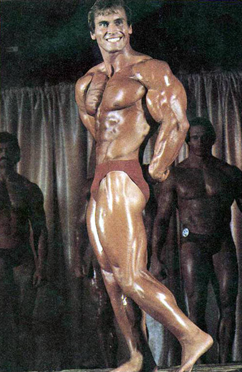 Lance Dreher posing at a competition and tensing his tricep and bicep