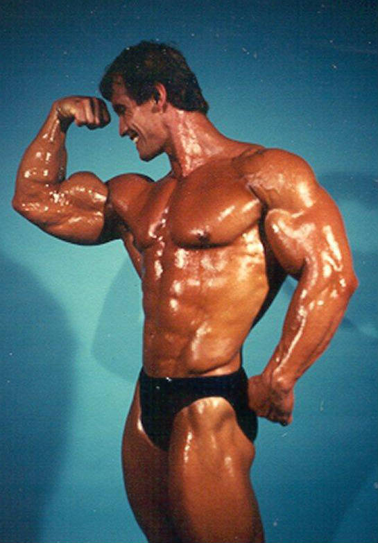 Lance Dreher tensing his bicep, oiled up before a competition