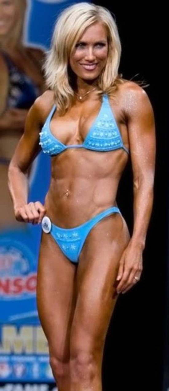 Lindy Olsen posing at competition and displaying her ripped and toned abs and chest