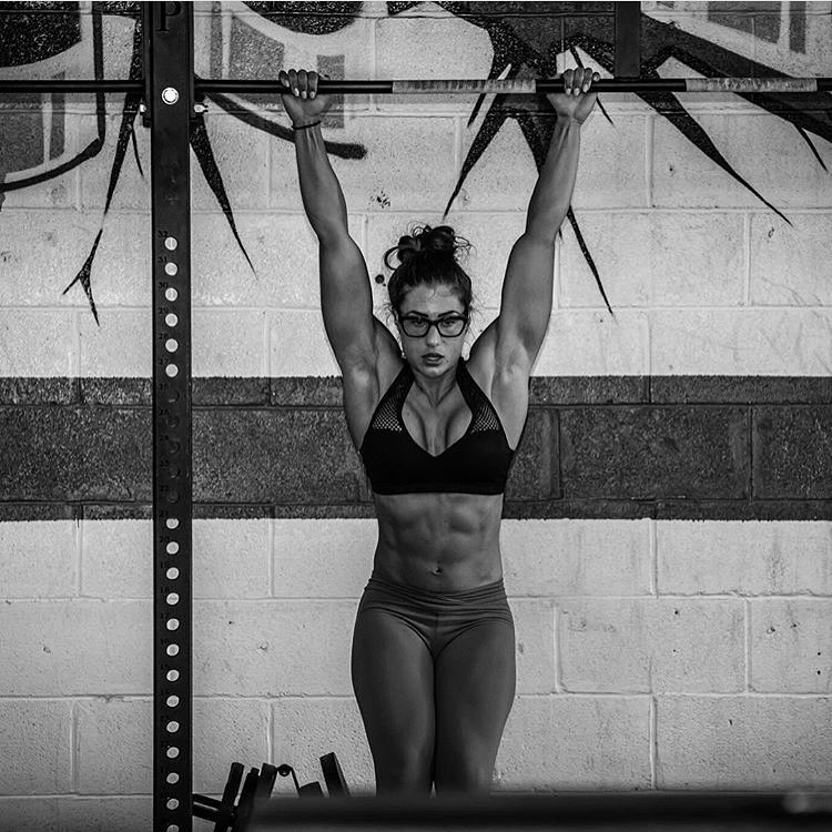 Margherita Di Bari doing hanging leg raises, with her abs flexed