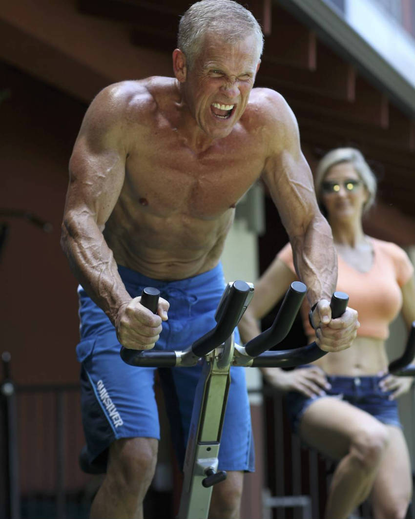 Mark Mcilyar on the bike, sweating anf showing his ripped abs and large arms