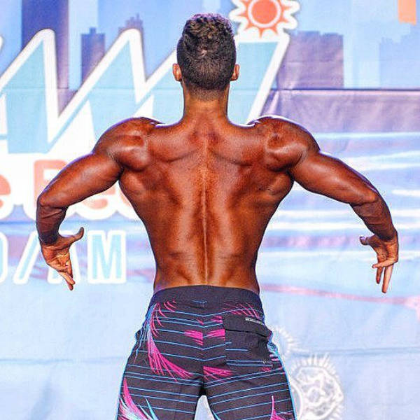 Maxime Parisishowing his toned back and large arms at a competition 