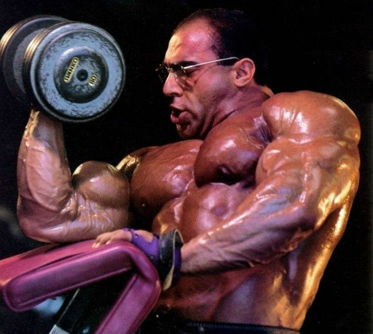 Nasser El Sonbaty completes a heavy bicep curl, showing his bulging bicep and his large chest