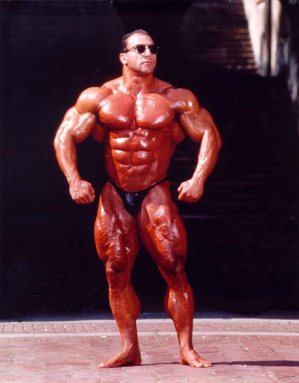Nasser El Sonbaty showing his full body before a competition, displaying his toned abs, chest, arms and quads