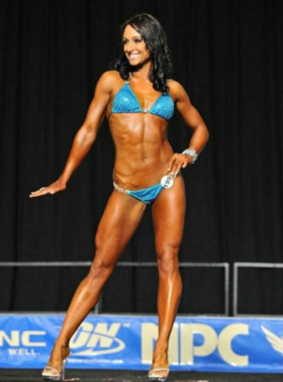Rachel Morrissey posing at a cmpetition, showing off her toned quads, ripped abs and toned biceps