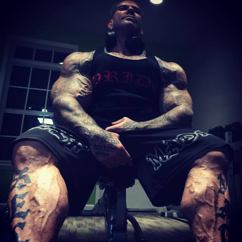 Rich Piana sitting, displaying his enormous and vascular calves