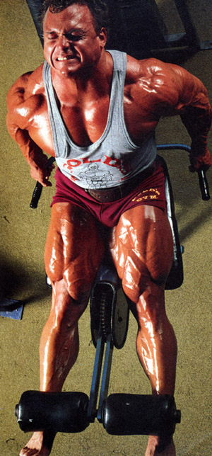 Tim Belknap completing a leg raise, showing his large quads, arms and calves