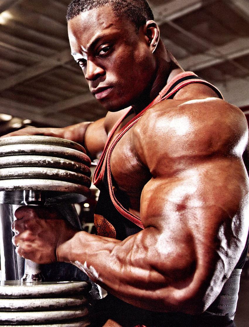 Brendon Ray flexing his bicep while holding a weight 