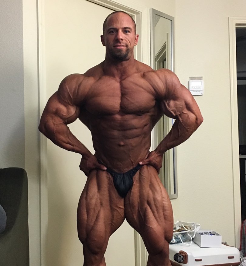 John Jewett in his room, showing his tanned-up, contest ready physique