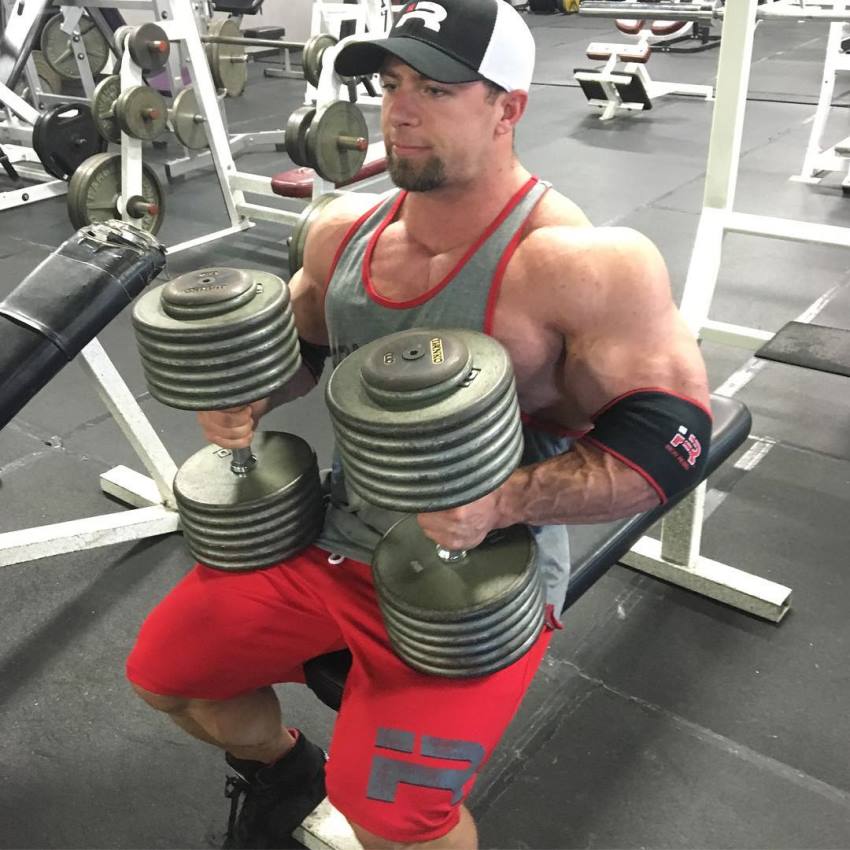 John Jewett preparing to do a heavy dumbbell bench press, looking big and muscular