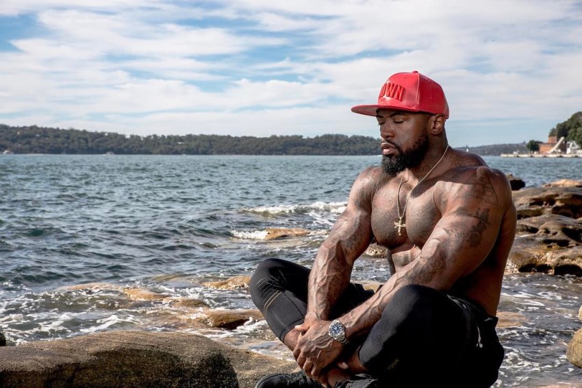 Mike Rashid meditating shirtless by the river, looking muscular and lean