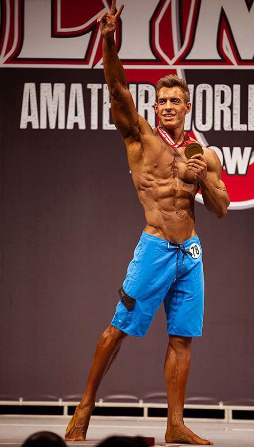 Nikolay Kuleshov standing on the Amateur Olympia stage, holding his medal in one hand, and waving to the audience with the other one