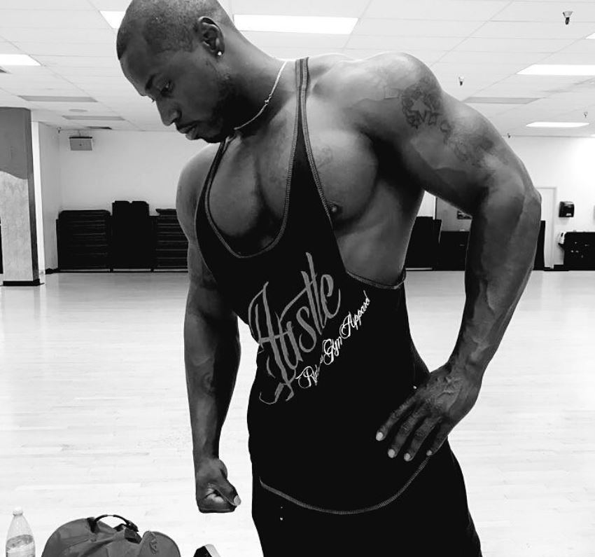 Otto Montgomery looking aesthetic and lean in his black tank top, standing in the gym hall