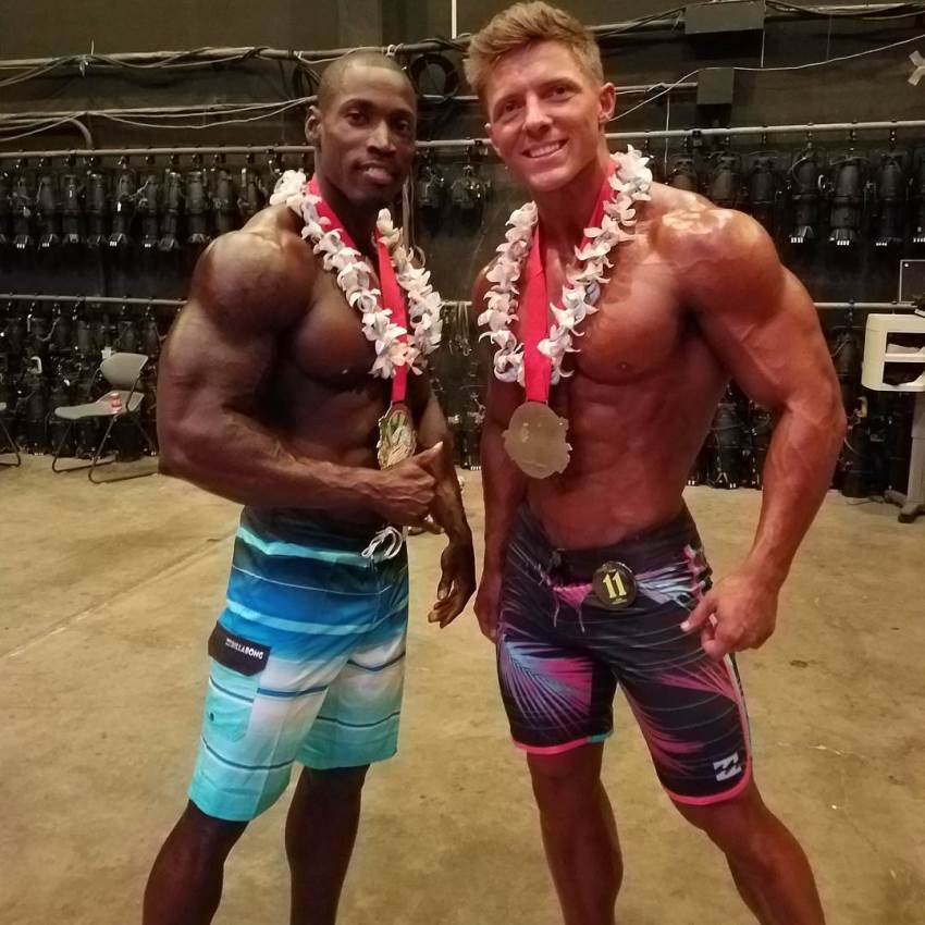 Otto Montgomery having a medal around his neck, standing next to Steve Cook, and posing for a picture together with him