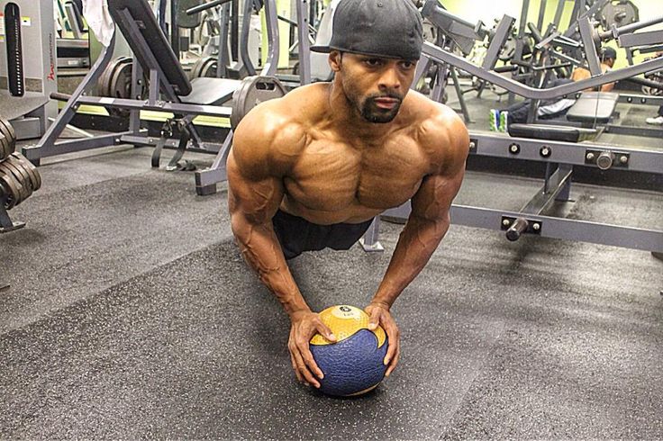 Ryan Hinton doing an exercise with a small ball in the gym, looking ripped and aesthetic