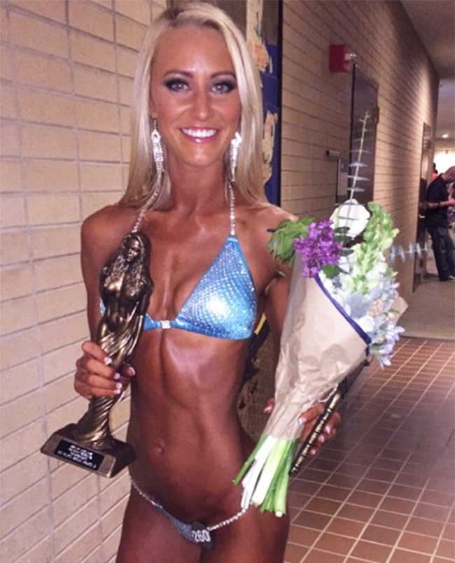 Shannon Henry in a bikini holding her first place trophy and flowers