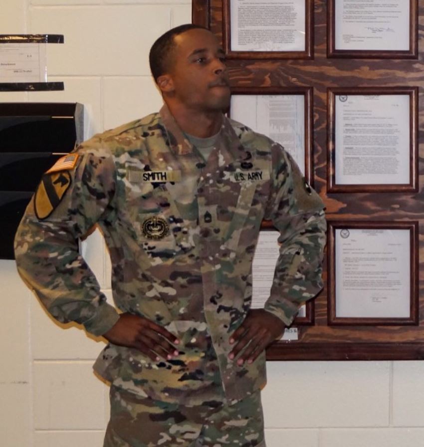 Andre Smith in his military suit, looking at something with a serious expression on his face