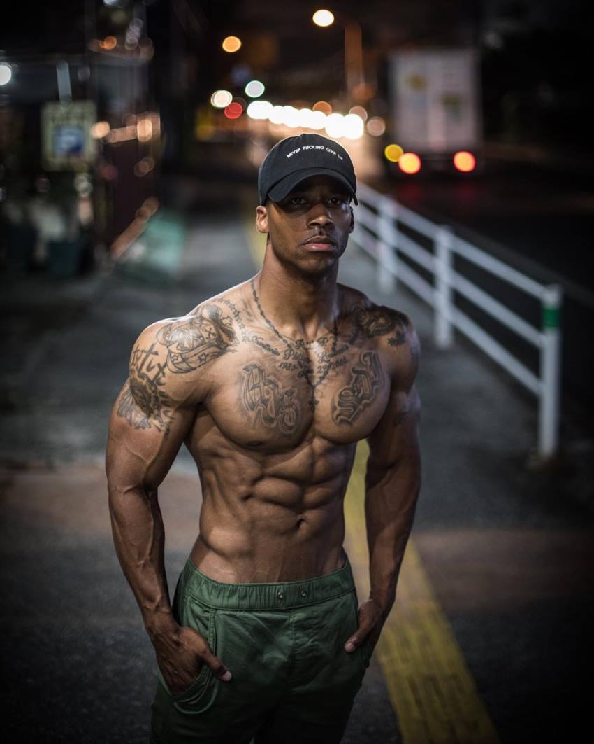 Andre Smith standing shirtless on the sidewalk, looking lean and muscular