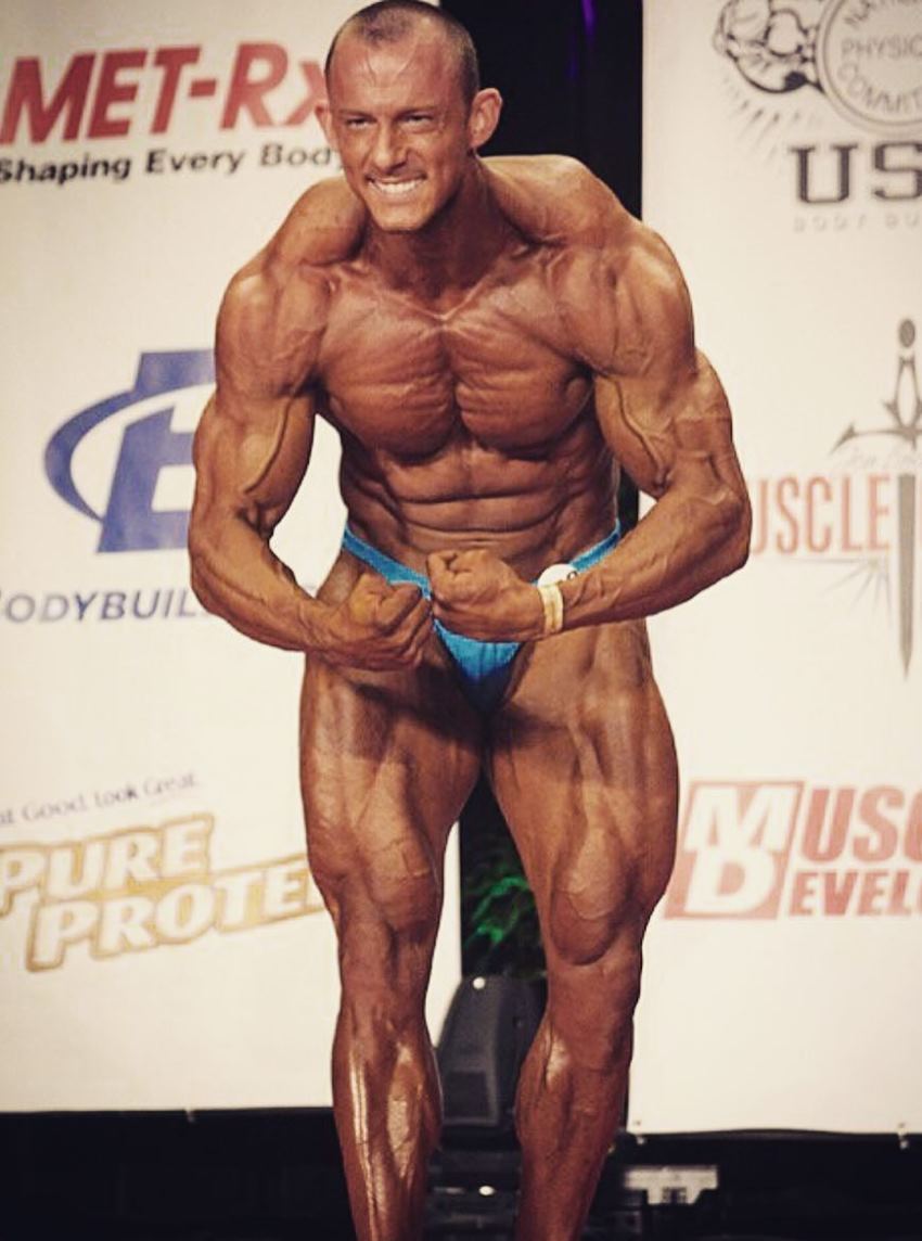 Brandon Gerdes performing a most muscular pose on the stage