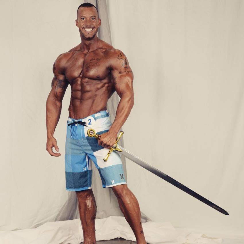 Brian Barthule posing with a sword after winning a contest, looking lean and aesthetic