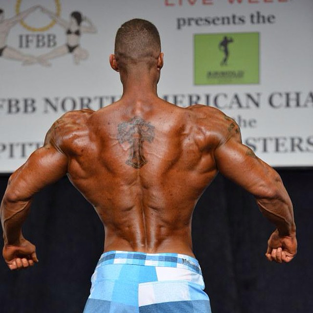 Brian Barthule showcasting his ripped back to the judges on the stage