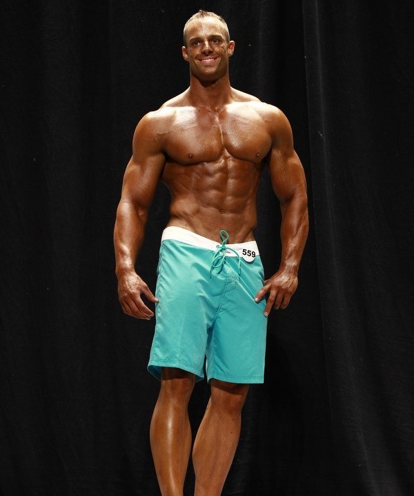 Coty Reutzel showing his tall and aesthetic frame to the judges on the bodybuilding stage