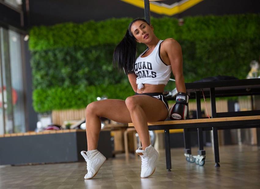 Giorgia Piscina sitting on a wodden bench, looking lean and fit