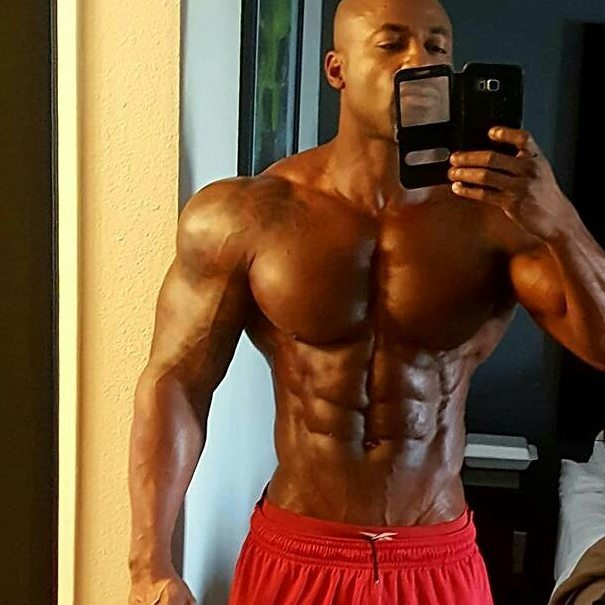 Jacques Lewis taking a selfie of his ripped abs, chest, arms, and shoulders