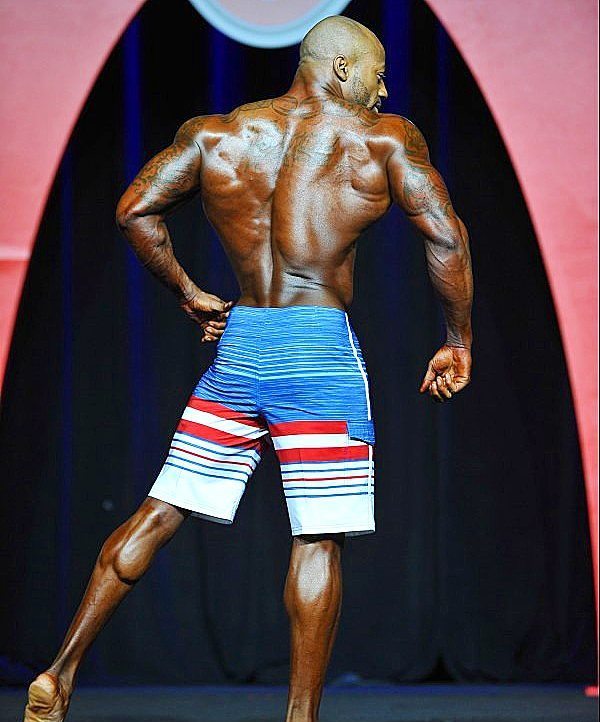 Jacques Lewis displaying his ripped back on the Mr. Olympia stage