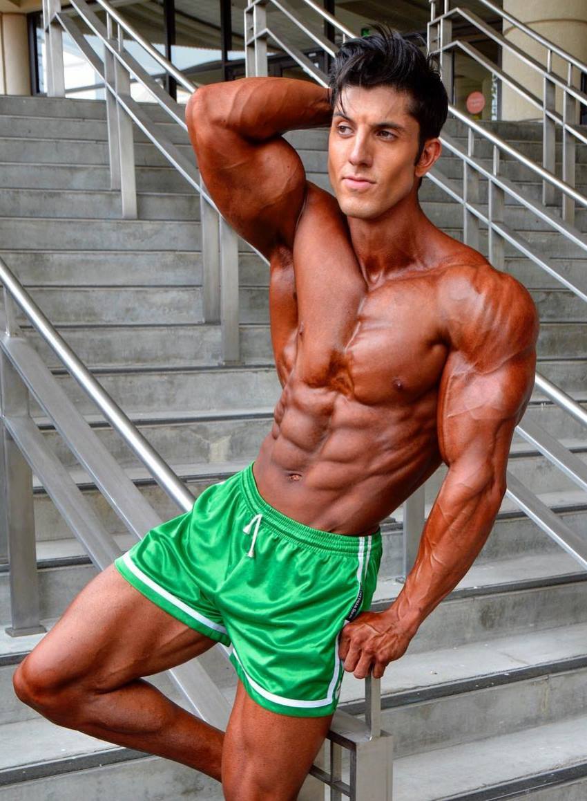 Jonny Bernstein wearing green shorts, tanned up, looking ripped and contest-ready