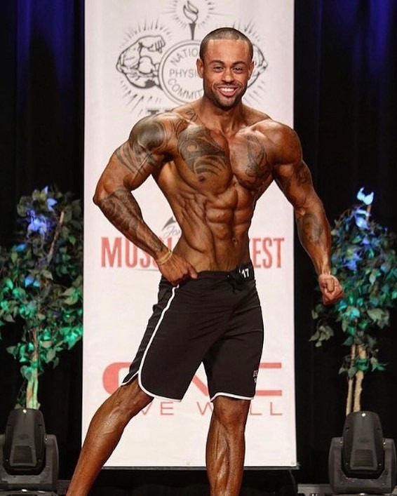 Kai Spencer displaying his conditioned and muscular physique on the Men's Physique bodybuilding stage