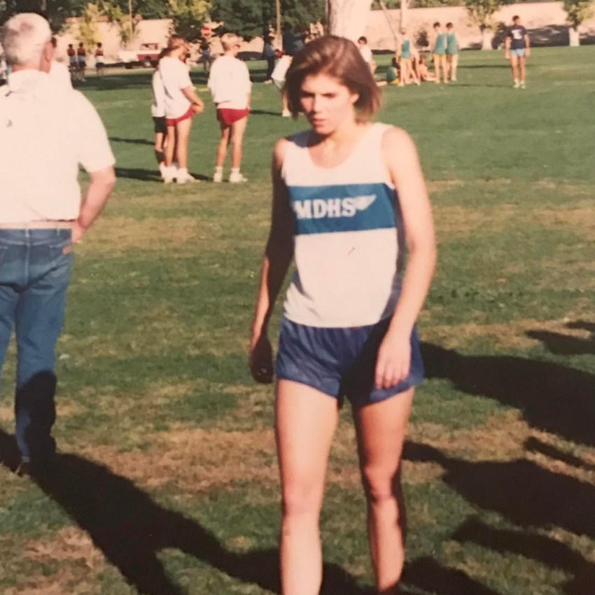 Torrie Wilson when she was a teenager, looking down at the grass as she walks through a field