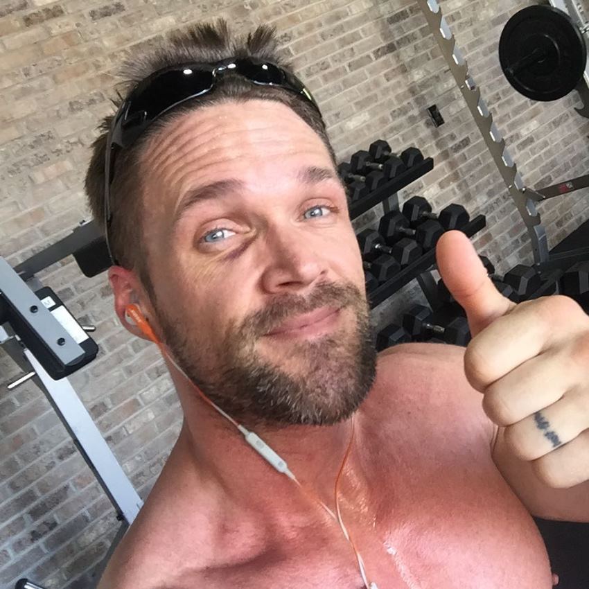 Chris Powell taking a selfie of himself in the gym, giving thumbs up to the camera