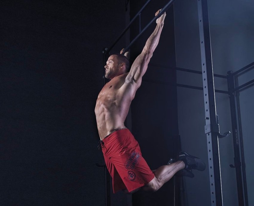 Chris Powell hanging on a bar, doing an exercise