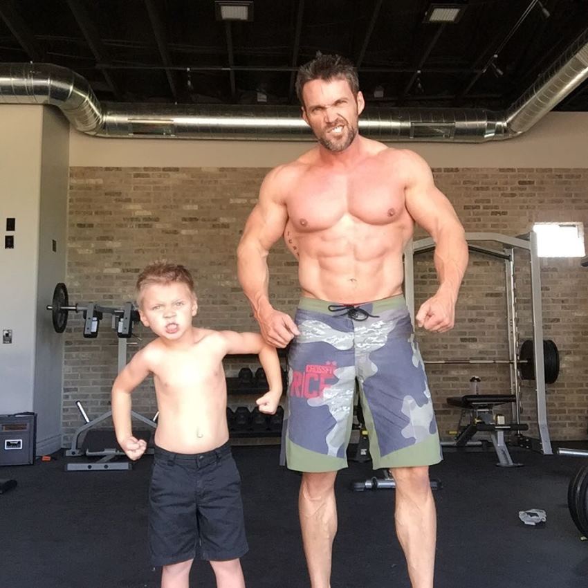 Chris Powell posing shirtless with his son, looking healthy and fit