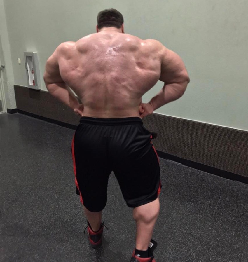 Craig Golias in a rear lat spread pose, looking massive and lean