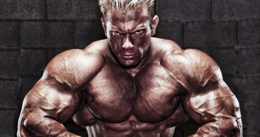 Dennis Wolf posing shirtless for a photo, looking massive and ripped, having a serious expression on his face